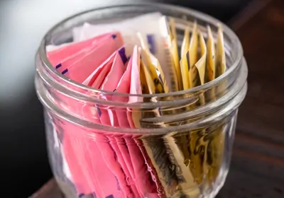 A jar full of artificial sweetener packets.